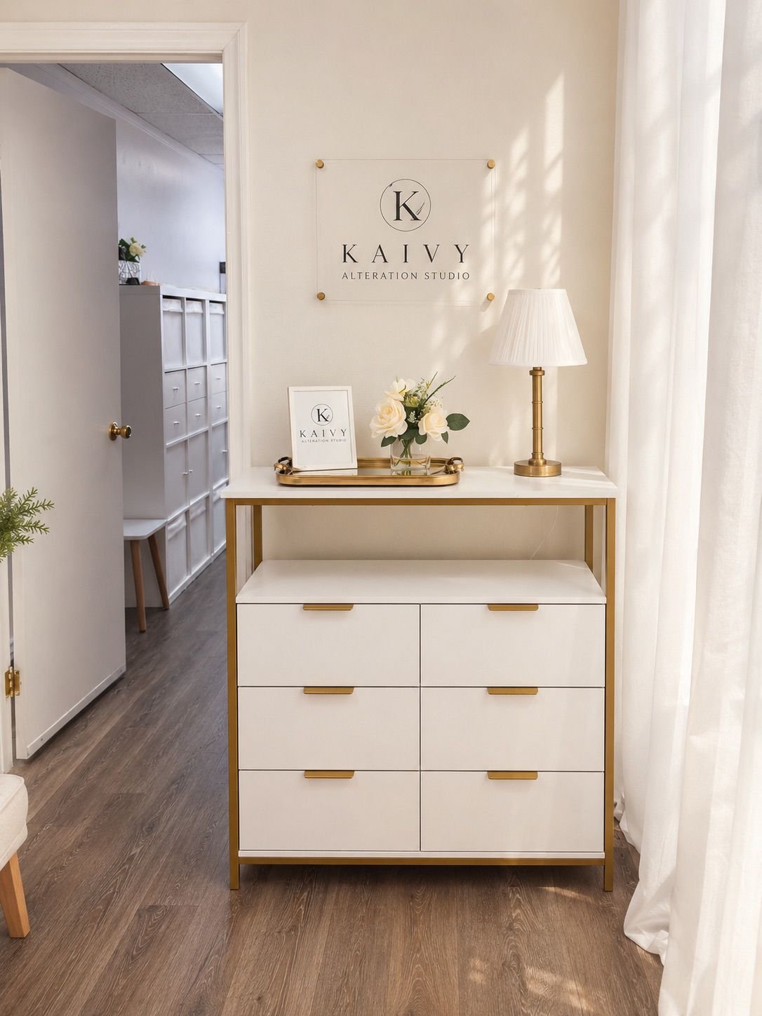 Interior of Kaivy Alteration Studio in Lake Forest, CA featuring the KAIVY sign and an elegant white and gold fitting area